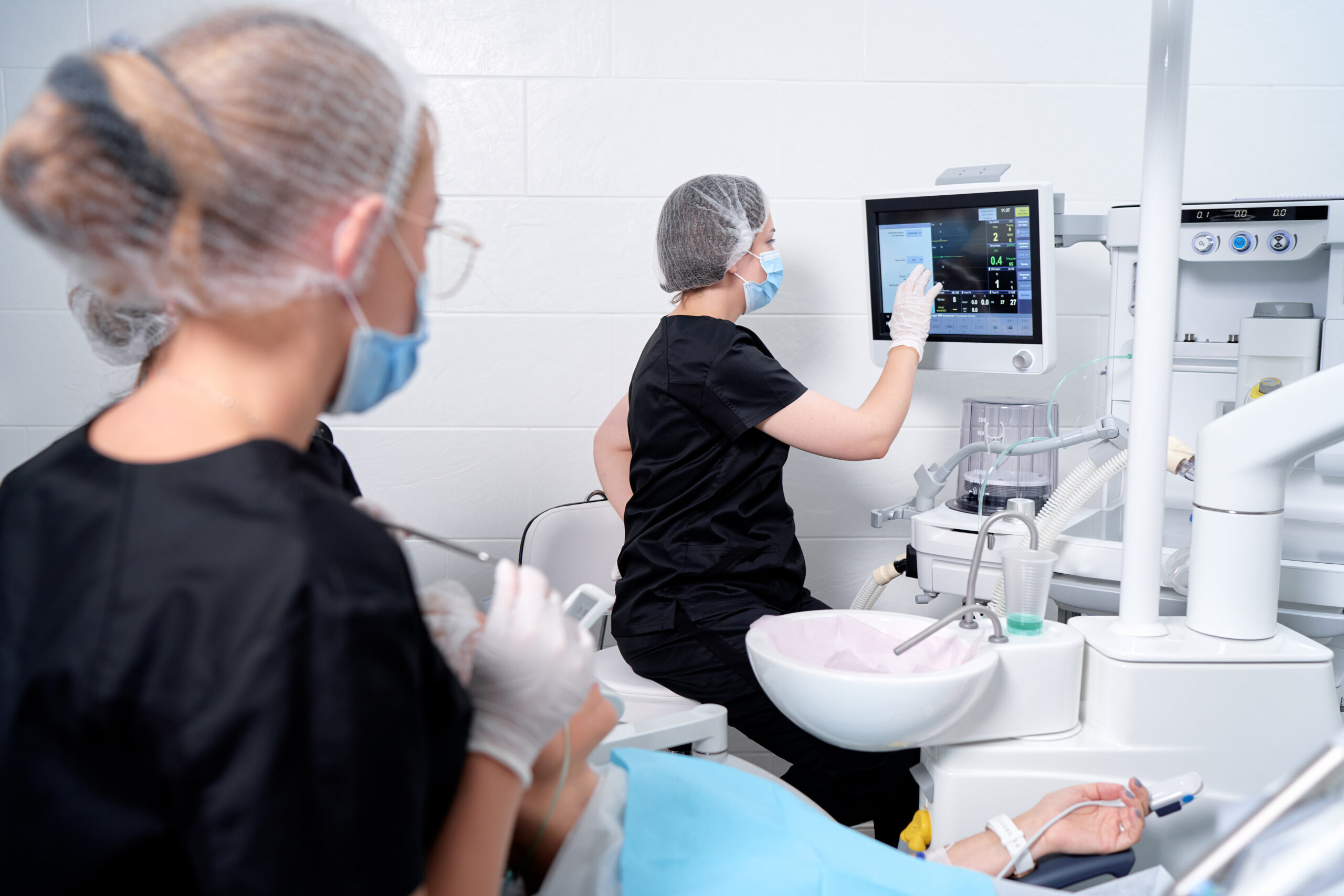 Doctor making anesthesia while female patient lying in dentist chair